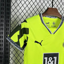 Criança usando o Kit Infantil Borussia Dortmund “Especial Anos 90” 2024/25 da PUMA, com camisa amarela em estilo retrô, gráficos ousados em preto e detalhes clássicos que remetem à década de 1990.