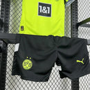 Criança usando o Kit Infantil Borussia Dortmund “Especial Anos 90” 2024/25 da PUMA, com camisa amarela em estilo retrô, gráficos ousados em preto e detalhes clássicos que remetem à década de 1990.