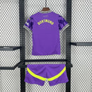 Criança com o Kit Infantil Goleiro Borussia Dortmund “Especial Anos 90” 2024/25 da PUMA, vestindo camisa de manga longa com estampa retrô colorida, short combinando e meias, em homenagem aos goleiros clássicos dos anos 1990.