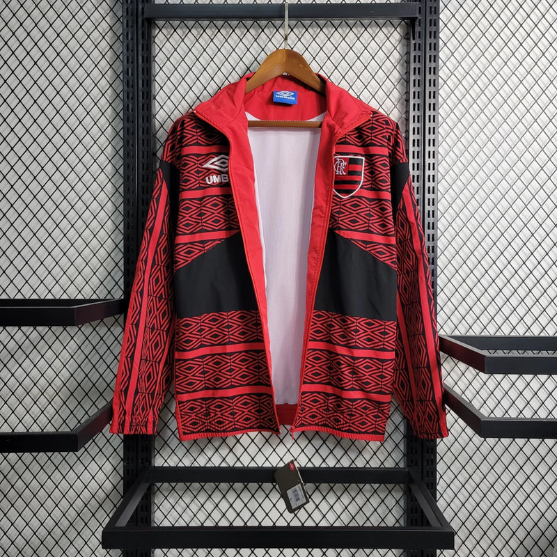 Corta Vento Flamengo Umbro Masculino nas cores vermelho e preto, com escudo do Flamengo no peito, zíper frontal e logo da Umbro – jaqueta esportiva para torcedores rubro-negros.