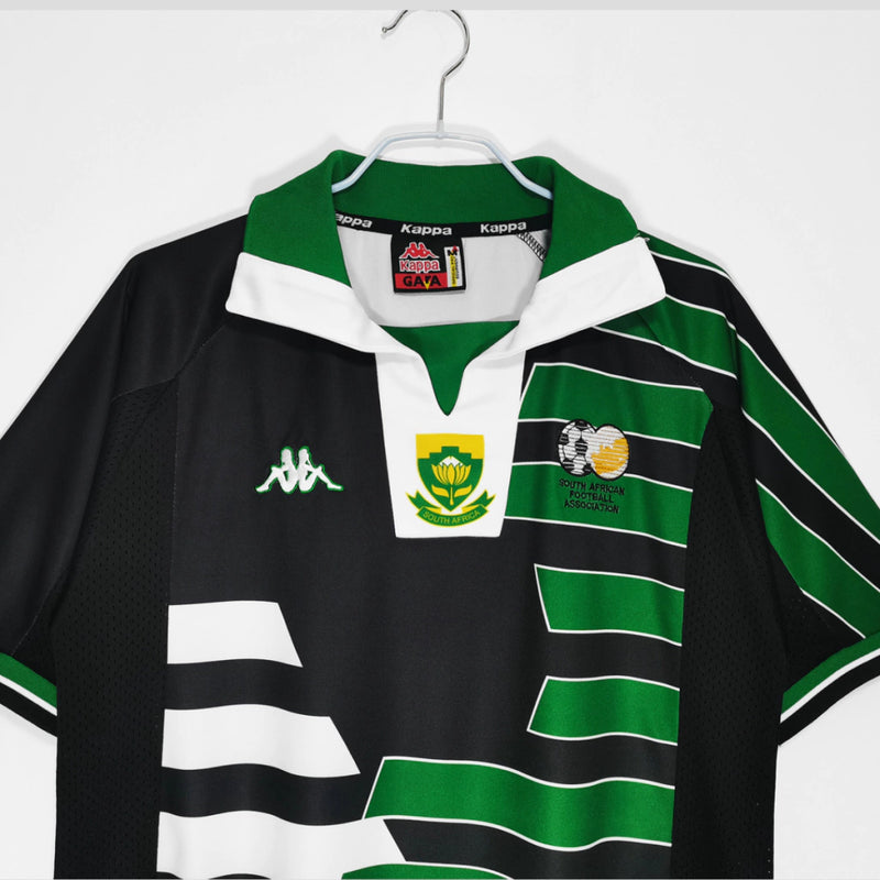 Camisa Retrô Seleção África do Sul Copa 1998 Torcedor Masculina - modelo preto, inspirado no uniforme clássico de 1998, escudo da seleção em destaque e design nostálgico para colecionadores e torcedores.