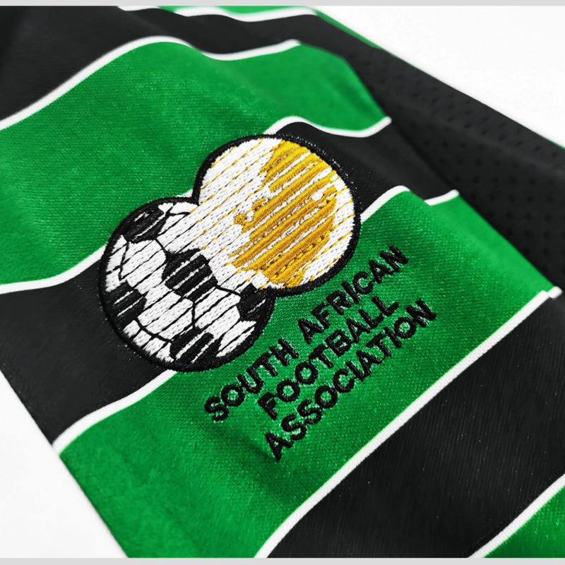 Camisa Retrô Seleção África do Sul Copa 1998 Torcedor Masculina - modelo preto, inspirado no uniforme clássico de 1998, escudo da seleção em destaque e design nostálgico para colecionadores e torcedores.