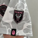 Camisa Inter Miami 2023/24 BAPE Torcedor Masculina - modelo cinza, edição especial em colaboração com a BAPE, escudo do clube em destaque e design exclusivo.