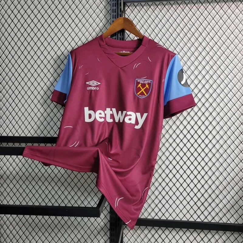 Camisa West Ham Home I 2023/24 Umbro Torcedor Masculina - modelo vinho, uniforme principal dos Hammers, escudo em destaque e design clássico assinado pela Umbro.