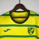 Camisa Norwich City Home I 2023/24 Torcedor Masculina - modelo amarelo com detalhes verdes, uniforme principal da temporada, apresentando escudo em destaque e design clássico que representa a identidade do clube.