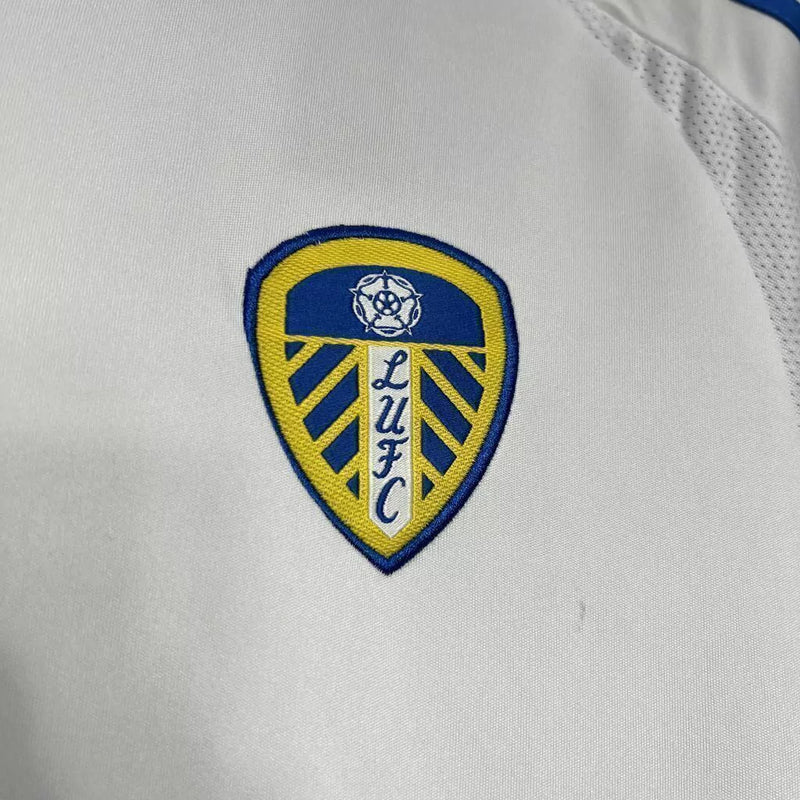 Camisa Leeds United Home I 2024/25 Adidas Torcedor Masculina - modelo branco, uniforme principal da temporada, com escudo em destaque e design clássico que simboliza a tradição e o orgulho do clube inglês.