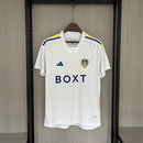 Camisa Leeds United Home I 2023/24 Torcedor Masculina - modelo branco, uniforme principal da temporada, com escudo em destaque e design clássico que reflete a tradição e o orgulho do clube inglês.
