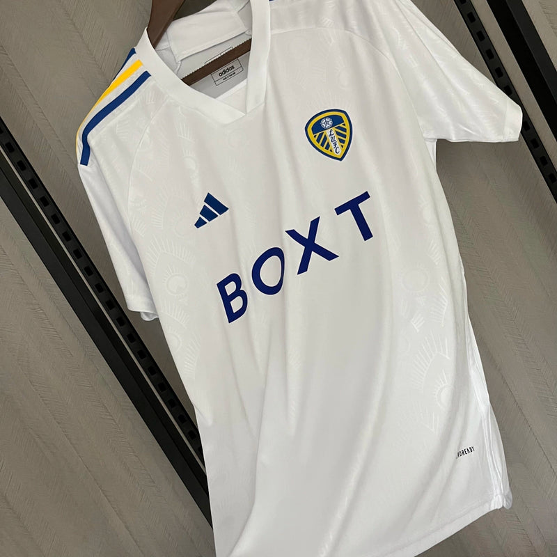Camisa Leeds United Home I 2023/24 Torcedor Masculina - modelo branco, uniforme principal da temporada, com escudo em destaque e design clássico que reflete a tradição e o orgulho do clube inglês.