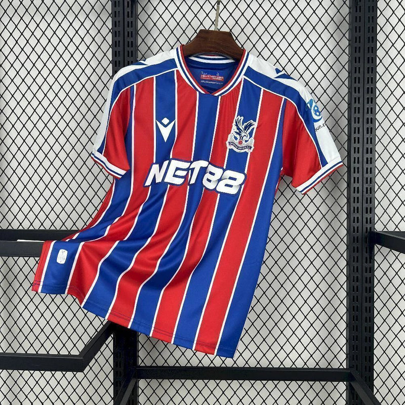 Camisa Crystal Palace Home I 2025/26 Torcedor Masculina - modelo azul e vermelho, uniforme principal da temporada, com listras verticais tradicionais, escudo do Crystal Palace bordado e design moderno que representa as cores icônicas do clube.