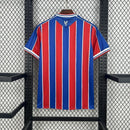 Camisa Crystal Palace Home I 2025/26 Torcedor Masculina - modelo azul e vermelho, uniforme principal da temporada, com listras verticais tradicionais, escudo do Crystal Palace bordado e design moderno que representa as cores icônicas do clube.