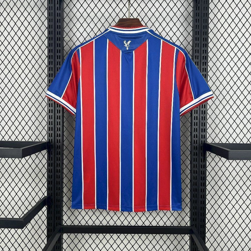 Camisa Crystal Palace Home I 2025/26 Torcedor Masculina - modelo azul e vermelho, uniforme principal da temporada, com listras verticais tradicionais, escudo do Crystal Palace bordado e design moderno que representa as cores icônicas do clube.