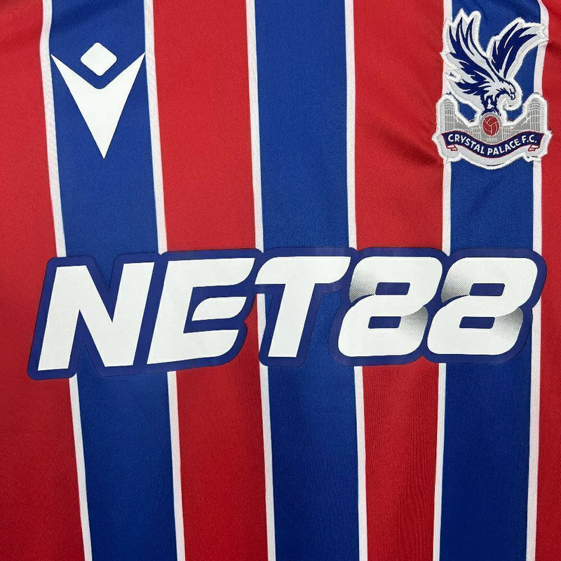 Camisa Crystal Palace Home I 2025/26 Torcedor Masculina - modelo azul e vermelho, uniforme principal da temporada, com listras verticais tradicionais, escudo do Crystal Palace bordado e design moderno que representa as cores icônicas do clube.