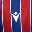 Camisa Crystal Palace Home I 2025/26 Torcedor Masculina - modelo azul e vermelho, uniforme principal da temporada, com listras verticais tradicionais, escudo do Crystal Palace bordado e design moderno que representa as cores icônicas do clube.