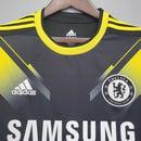 Camisa Chelsea Third III 2012/13 Adidas Torcedor Masculina - modelo preto com detalhes em dourado, três listras douradas nos ombros, escudo do Chelsea bordado no peito e logotipo da Adidas centralizado, design clássico da temporada 2012/13.