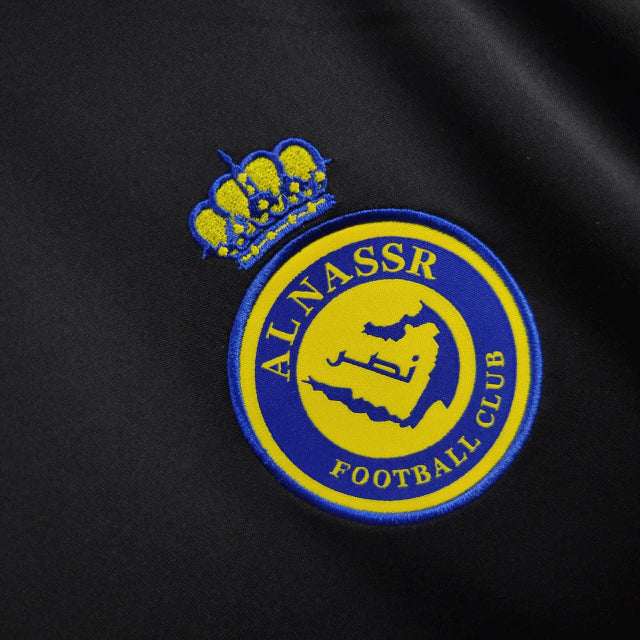 Camisa Al-Nassr Treino 2024/25 Adidas Torcedor Masculina azul marinho com detalhes amarelos, escudo do Al-Nassr no peito e logo Adidas, modelo oficial para treinos e uso casual.