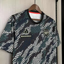 Camisa Arsenal Pré-Jogo Maharishi 2023/24 Adidas Torcedor Masculina verde com detalhes discretos, escudo do Arsenal e logo Adidas.