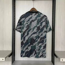 Camisa Arsenal Pré-Jogo Maharishi 2023/24 Adidas Torcedor Masculina verde com detalhes discretos, escudo do Arsenal e logo Adidas.