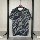 Camisa Arsenal Pré-Jogo Maharishi 2023/24 Adidas Torcedor Masculina verde com detalhes discretos, escudo do Arsenal e logo Adidas.