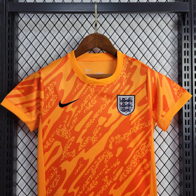 Kit Infantil Inglaterra Goleiro 2024/25 Nike na cor laranja vibrante, com camisa e shorts oficiais, escudo bordado da seleção inglesa e tecnologia Dri-FIT para máximo conforto."

