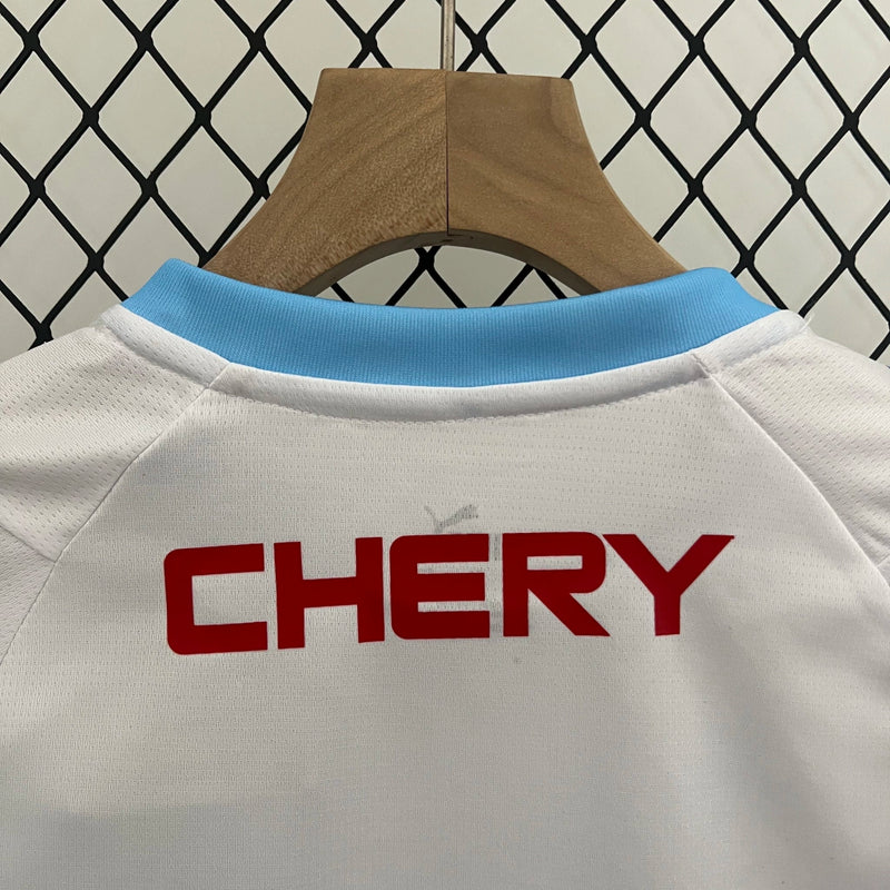 Kit Infantil Universidad Católica 2024/25 Puma – camisa azul com detalhes em branco e shorts combinando, uniforme infantil oficial da Universidad Católica, leve, respirável e confortável para crianças de 3 a 13 anos."