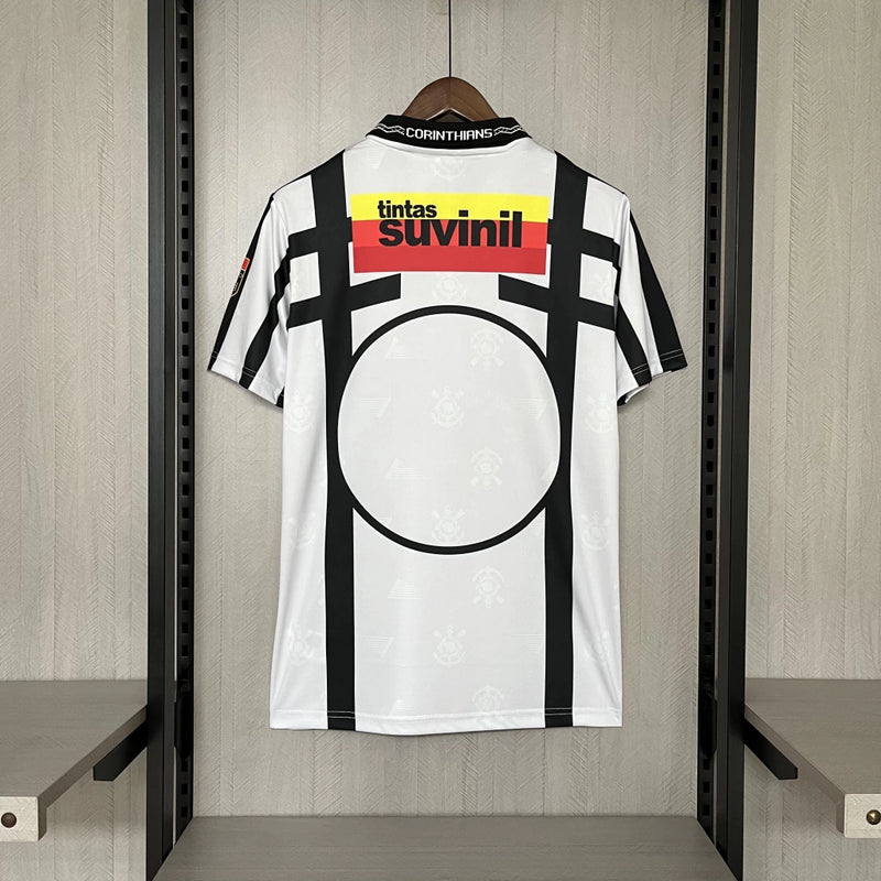 Camisa retrô Corinthians Suvinil 1990 Penalty masculina, cor branca com listras pretas horizontais e verticais, escudo bordado no peito e gola polo com detalhes da marca Penalty.