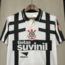 Camisa retrô Corinthians Suvinil 1990 Penalty masculina, cor branca com listras pretas horizontais e verticais, escudo bordado no peito e gola polo com detalhes da marca Penalty.