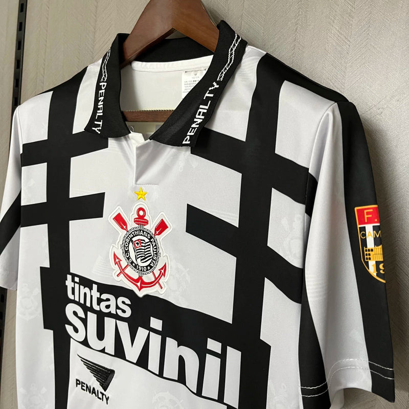 Camisa retrô Corinthians Suvinil 1990 Penalty masculina, cor branca com listras pretas horizontais e verticais, escudo bordado no peito e gola polo com detalhes da marca Penalty.