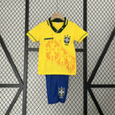 Kit Infantil Brasil Home 1994 Umbro, camisa amarela com detalhes verdes e azuis, shorts e meias combinando, uniforme retrô oficial para crianças de 3 a 13 anos torcedoras da Seleção Brasileira."
