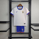 Kit Infantil França Away 2024/25 Nike – camisa azul escuro com detalhes em vermelho e branco e shorts combinando, uniforme infantil oficial da seleção francesa, leve, respirável e confortável para crianças de 3 a 13 anos."