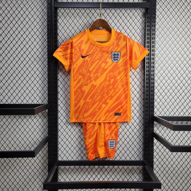 Kit Infantil Inglaterra Goleiro 2024/25 Nike na cor laranja vibrante, com camisa e shorts oficiais, escudo bordado da seleção inglesa e tecnologia Dri-FIT para máximo conforto."
