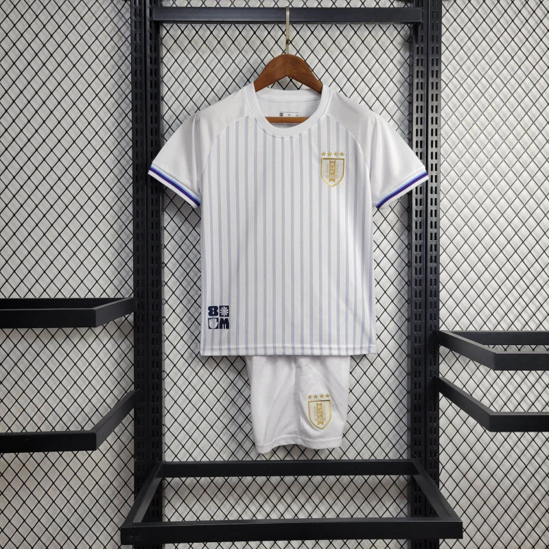 Kit Infantil Uruguai Away (2) 2024/25 – Camisa branca com detalhes em azul celeste e shorts oficial, uniforme leve, confortável e ideal para crianças de 3 a 13 anos."