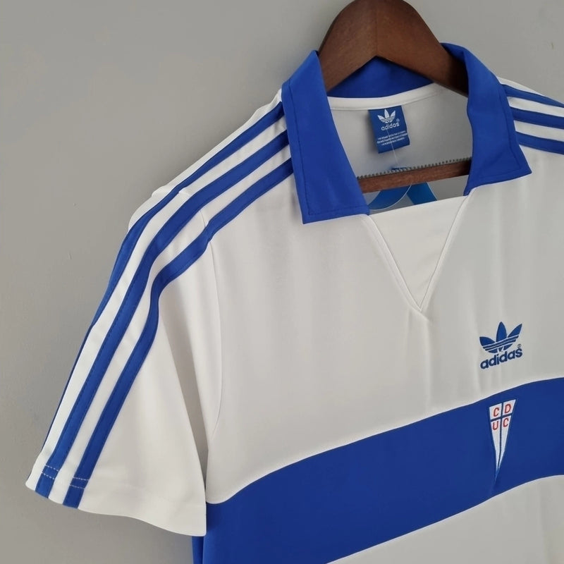 Camisa Universidad Católica Home I 1984/85 Adidas Retrô Masculina branca, modelo clássico dos anos 80 com detalhes em azul, escudo bordado e design histórico do futebol chileno.