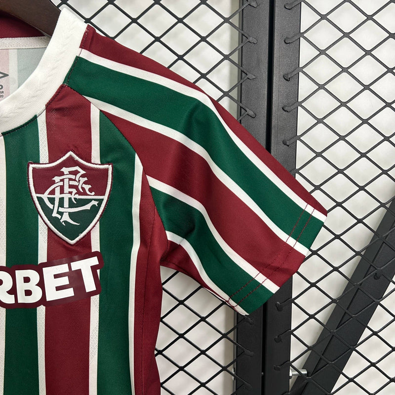 Kit Infantil Fluminense Home 2025/26 Umbro, camisa tricolor verde, grená e branca com shorts e meias combinando, uniforme oficial para crianças de 3 a 13 anos torcedoras do Fluminense."