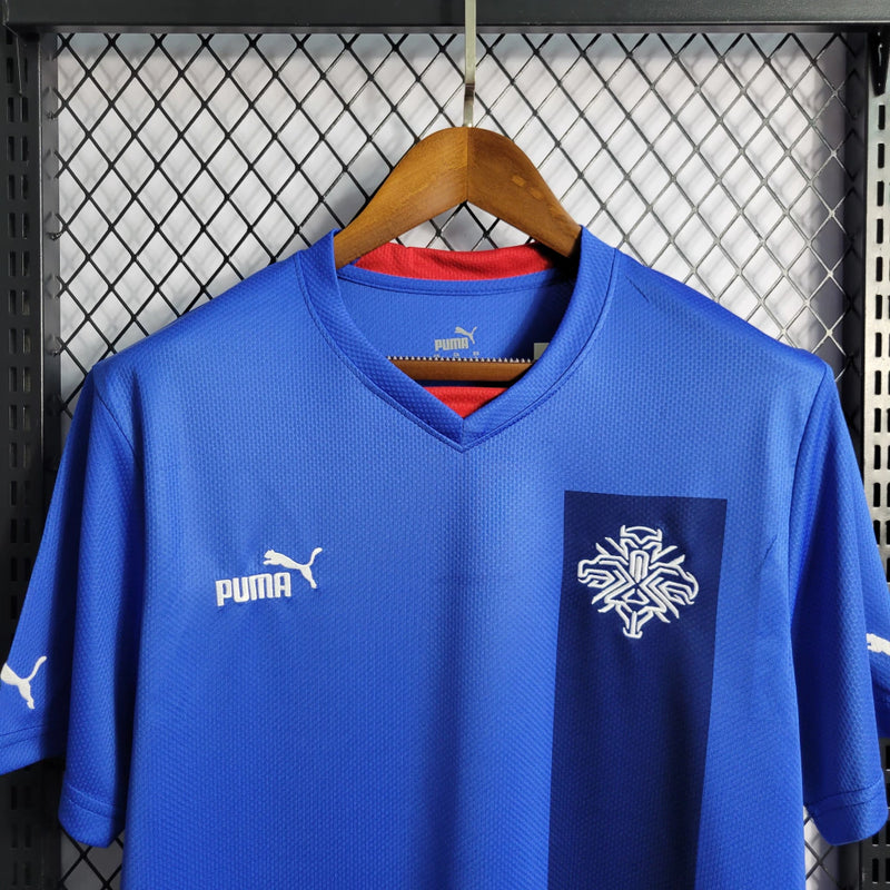 "Camisa Islândia Home I 2022/23 Puma masculina azul com detalhes em branco e vermelho, gola careca, mangas curtas e tecido leve respirável para torcedores"
