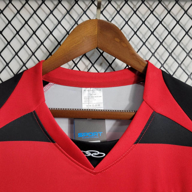 Camisa Flamengo Home I 2010/11 Olympikus vermelha e preta com listras horizontais, leve e respirável, ideal para torcedores Rubro-Negros e colecionadores de camisas históricas."