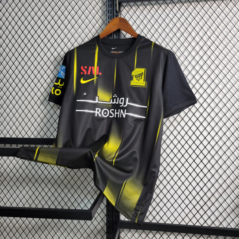 Camisa Al-Ittihad Away II 2023/24 Nike Torcedor Masculina preta, uniforme oficial do clube saudita, design moderno com detalhes amarelos, escudo em destaque e tecnologia Nike Dri-FIT para conforto e performance.