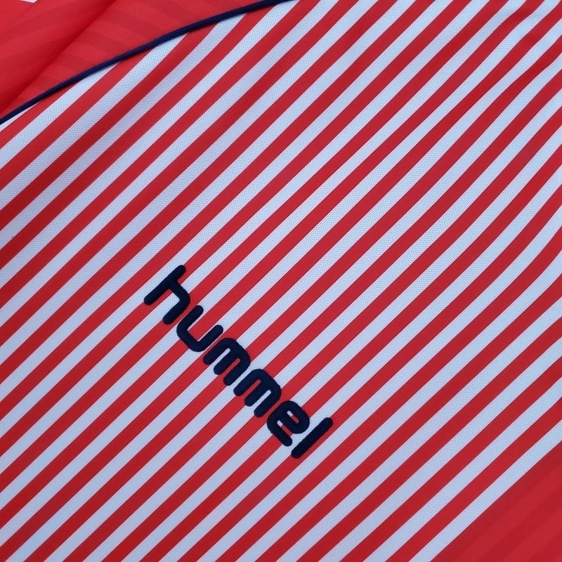 Camisa Dinamarca Home I 1986/87 Hummel Retrô Masculina, vermelha, com escudo da seleção dinamarquesa e logo Hummel bordados, feita em tecido leve e confortável, modelo retrô masculino com caimento tradicional, ideal para colecionadores e uso casual.”