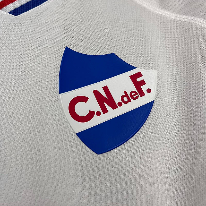 Camisa Nacional Uruguai Treino Umbro 2025/26 Torcedor Masculina Branca com escudo bordado e logo da Umbro, modelo oficial para torcedores do Club Nacional de Football.