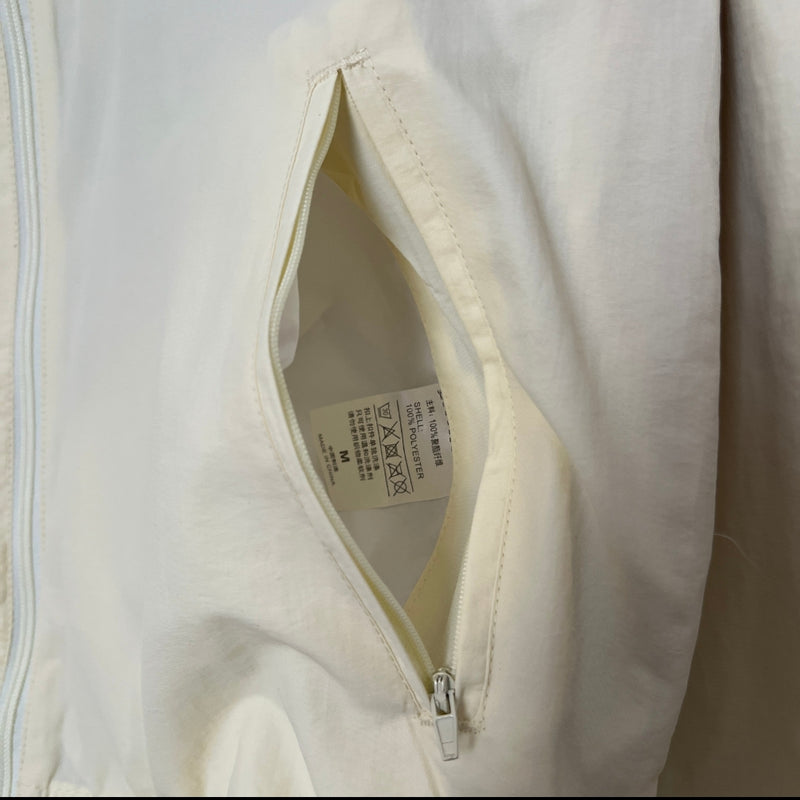 Detalhe da camisa Nike Corinthians 110 Anos 2023 bege com escudo do clube e tecido tecnológico.