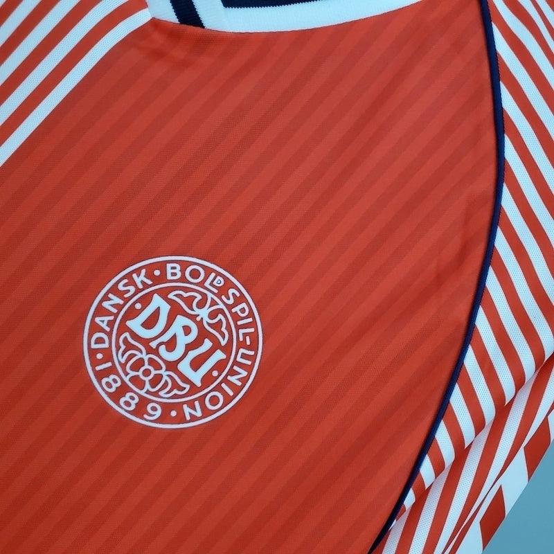 Camisa Dinamarca Home I 1986/87 Hummel Retrô Masculina, vermelha, com escudo da seleção dinamarquesa e logo Hummel bordados, feita em tecido leve e confortável, modelo retrô masculino com caimento tradicional, ideal para colecionadores e uso casual.”