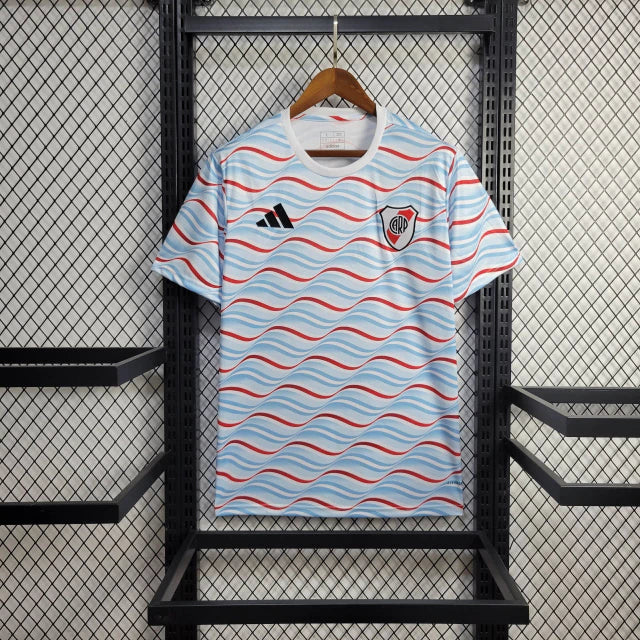 Texto alternativo para imagem:
Camisa River Plate Pré-Jogo 2024/25 Adidas Torcedor Masculina preta com detalhes gráficos em vermelho e branco, escudo do River Plate no peito e logo da Adidas estampado, modelo oficial para aquecimento dos jogadores.

