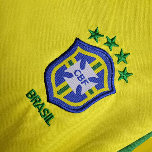 Kit Infantil Brasil Home 2002 Nike Retrô – uniforme completo com camisa amarela, shorts azul e meião branco, inspirado no penta da Copa do Mundo, confortável e ideal para crianças apaixonadas por futebol."