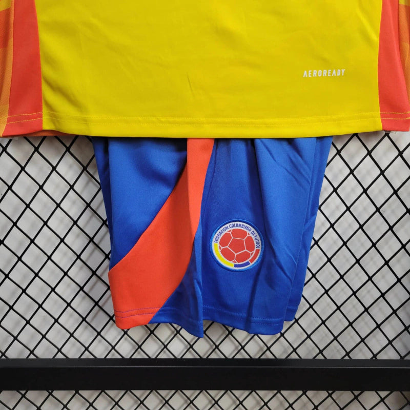 Kit Infantil Colômbia Home (1) 2024/25 Adidas oficial, camisa amarela com detalhes em azul e vermelho, escudo da FCF em destaque, shorts combinando, uniforme completo para crianças de 3 a 13 anos"