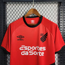 Camisa Athletico Paranaense Home (1) 2023/24 Umbro Torcedor Masculina com escudo oficial bordado e logo Umbro estampado, modelo clássico vermelho e preto do clube paranaense.