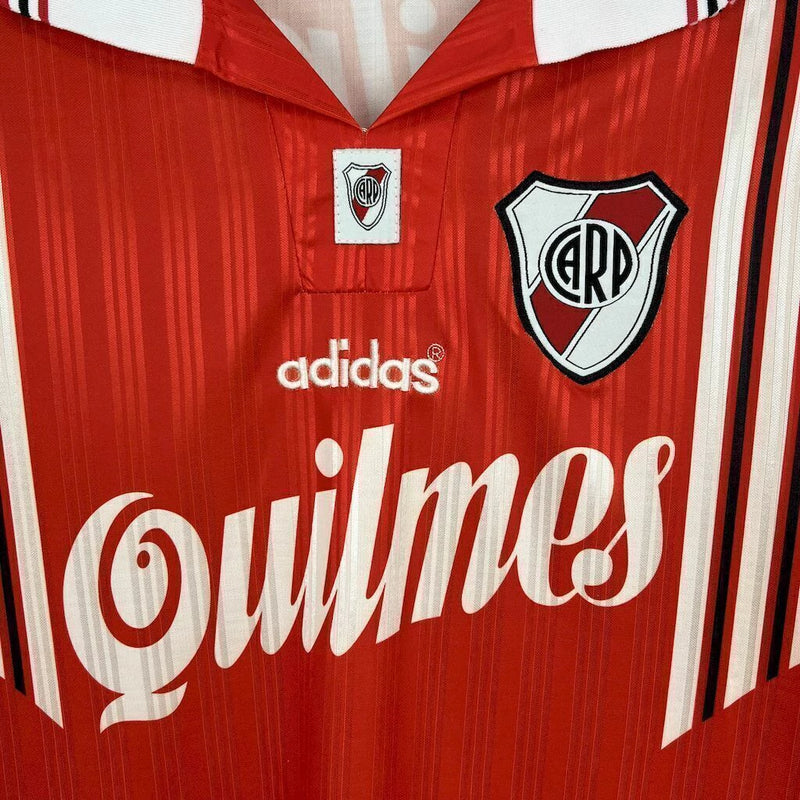 Camisa River Plate Home (1) 1996/98 Adidas Retrô Masculina, modelo branco com faixa diagonal vermelha, escudo bordado e logo clássico da Adidas, inspirada no uniforme histórico usado pelo clube argentino nos anos 90.

