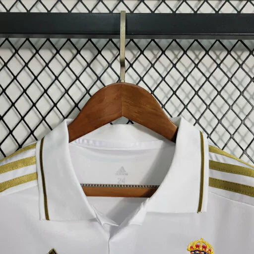 Kit Infantil Real Madrid Retrô 2011/12 Adidas oficial, camisa branca com escudo do Real Madrid em destaque, shorts e meias combinando, uniforme completo para crianças de 3 a 13 anos"