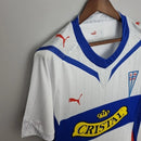 Camisa Retrô Universidad Católica Home I 2009/10 Puma Masculina branca, uniforme titular clássico do futebol chileno com escudo da Católica no peito, design retrô, ideal para torcedores e colecionadores.