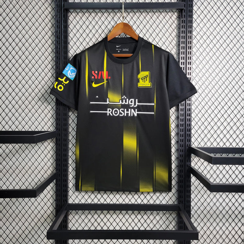 Camisa Al-Ittihad Away II 2023/24 Nike Torcedor Masculina preta, uniforme oficial do clube saudita, design moderno com detalhes amarelos, escudo em destaque e tecnologia Nike Dri-FIT para conforto e performance.