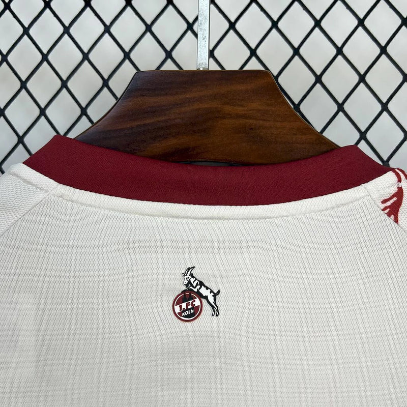 Camisa 1. FC Köln 'Kölsch Mädche' 2024/25 Hummel Torcedor Masculina branca com detalhes vermelhos e pretos, escudo bordado do clube e logo Hummel, modelo oficial para torcedores do futebol alemão.