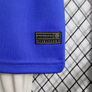 Kit Infantil Brasil Away 2022/23 Nike, camisa azul com detalhes em branco, shorts e meias combinando, uniforme oficial para crianças de 3 a 13 anos torcedoras da Seleção Brasileira."